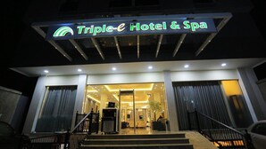 Exterior del Triple Hotel & Spa, con una entrada moderna, puertas de vidrio y una escalera que conduce a la entrada.
