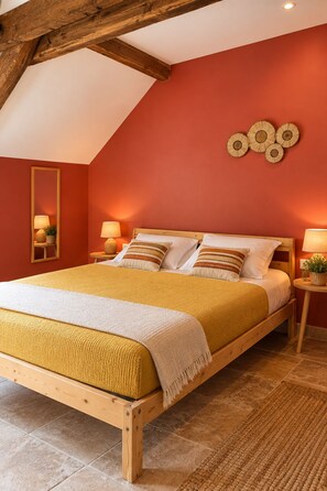Une chambre à coucher avec un lit en bois, des murs rouges et un plafond en pente.