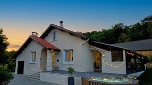 Una casa moderna con un patio, jacuzzi y un espacio exterior cubierto.