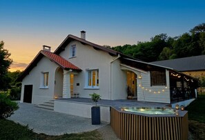 Une maison moderne dotée d’un patio, d’un jacuzzi et d’un espace extérieur couvert.