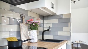 Eine moderne Küche mit schwarzem Arbeitsplatz, einem Spülbecken und einer Blumenvase.