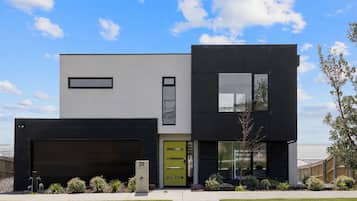 A modern two-story house with a garage, a green door, and a number 35 mailbox.