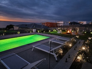 A swimming pool with a geometric design, surrounded by lounge chairs and a fire pit. - The Bay View San Remo by Ready Set Stay (San Remo)