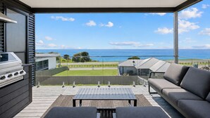 A balcony with a view of the sea, a barbecue grill, and a sofa. - The Bay View San Remo by Ready Set Stay (San Remo)