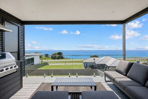 A balcony with a view of the sea, a barbecue grill, and a sofa. - The Bay View San Remo by Ready Set Stay (San Remo)