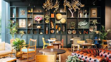 Un interior acogedor con arreglos de asientos, diversos objetos decorativos en estantes y un techo con instrumentos de metal colgados.