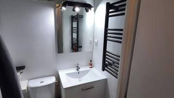 Chuveiro, toalhas de banho, papel higiênico