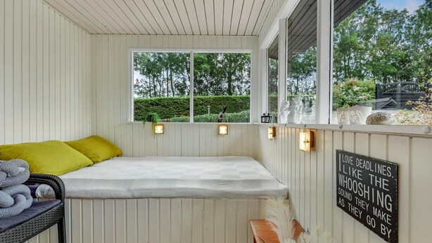 Ein gemütliches Zimmer mit einem Bett, einem Fenster mit Blick auf Grünflächen und einem Schild an der Wand.