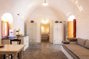 A cozy, rustic interior with a kitchen, dining area, and a cozy seating area. - Santa Irini Retreat (Therasia)