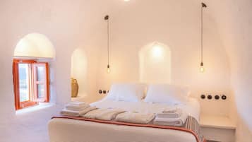 Un dormitorio con una cama, un banco y una ventana con vistas.