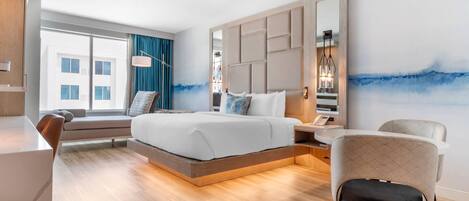 Une chambre d’hôtel moderne, dotée d’un grand lit, d’un bureau et d’une chaise.