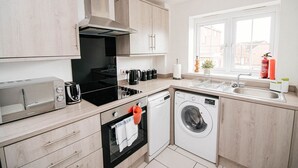 A modern kitchen with a built-in oven, microwave, toaster, and dishwasher. - Sandall Apartment (Doncaster)