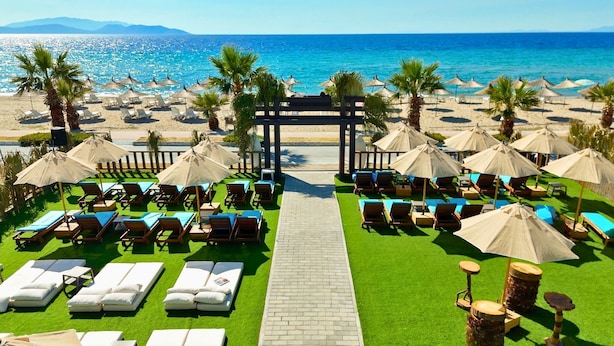A beachside resort with sun loungers, umbrellas, and a clear view of the ocean. - Seven For Life Thermal Hotel (Kusadasi)