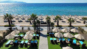 A beachside resort with a pool area, sun loungers, and umbrellas. - Seven For Life Thermal Hotel (Kusadasi)
