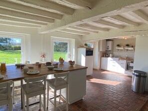 Enjoy cooking and dining in this inviting kitchen and dining area, featuring a large window with a view of the surrounding greenery.