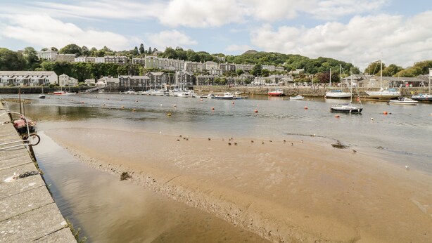 Une ville côtière dotée d’une plage de sable, de bateaux et de bâtiments qui bordent la côte.