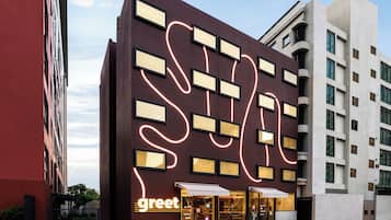 A modern building with a prominent 'greet' sign, large windows, and a unique neon light design.
