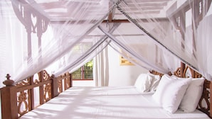 A large, well-lit room with a wooden bed and a canopy. - Villa Pundamilia, Private Pool, Free Wifi, Secure (Diani Beach)