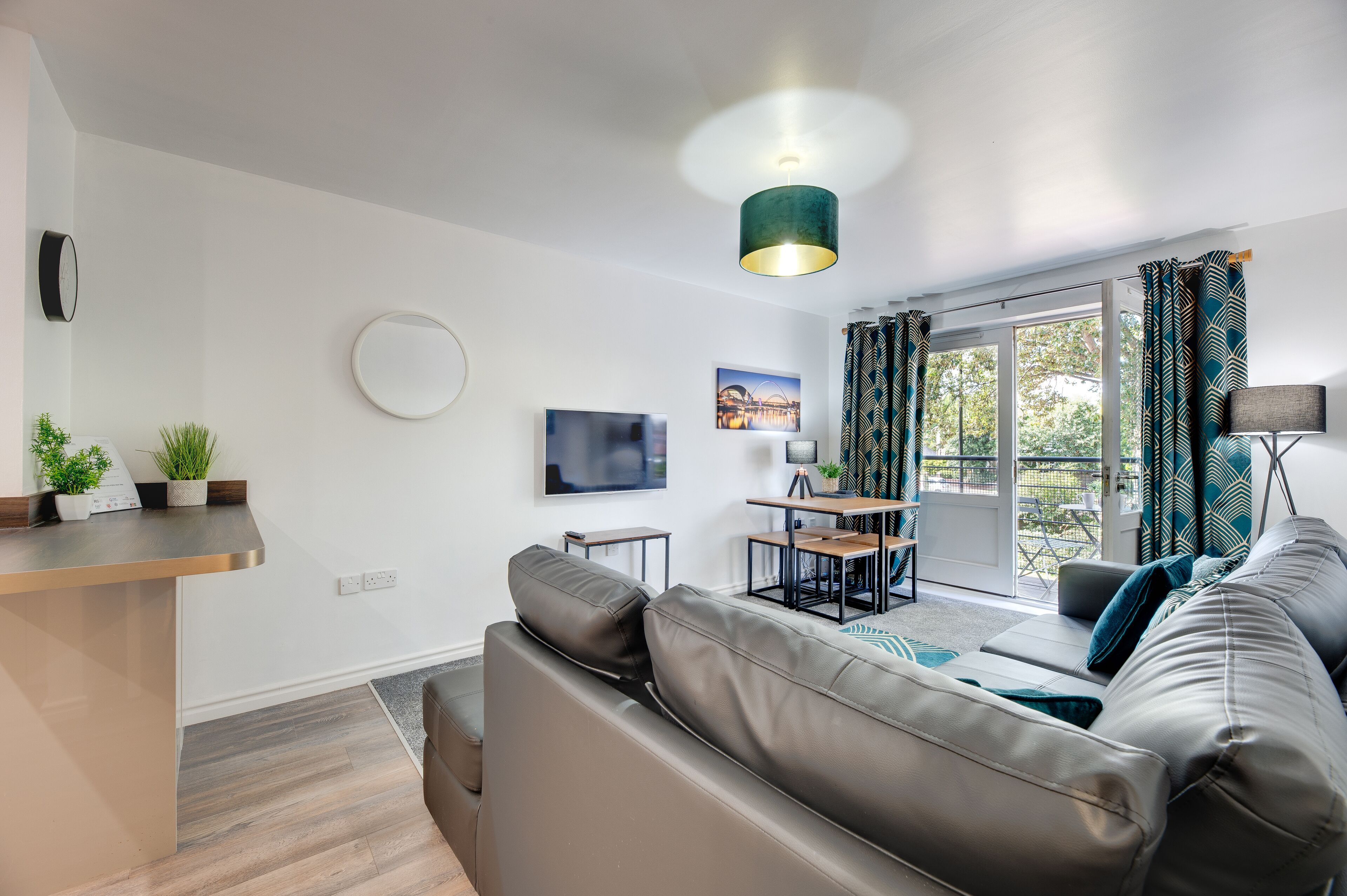 A modern living room with a sofa, a dining table, and a TV.