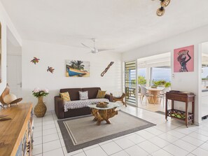 A spacious living area with a sofa, coffee table, and a view to the outside.
