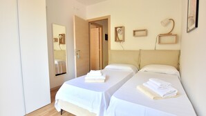 A hotel room with two beds, a mirror, a bedside lamp, and a framed picture on the wall. - Apartment Borgo Montagna With Pool (San Zeno di Montagna)
