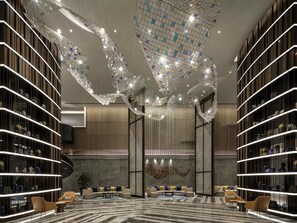 A modern interior with a curved sofa, bookshelves, and a decorative ceiling. - Pullman Huai’an (Huai'an)