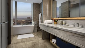 A modern bathroom with a large bathtub, a vanity with two sinks, and a large mirror. - Pullman Huai’an (Huai'an)