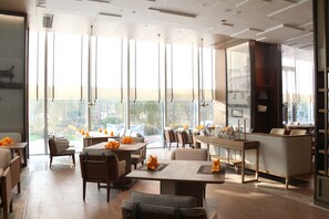 Un comedor moderno con techos altos, ventanas amplias y vistas al exterior.
