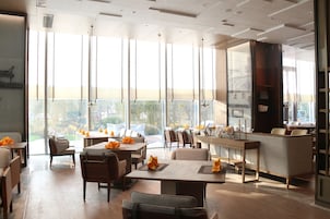 Un comedor moderno con techos altos, ventanas amplias y vistas al exterior.
