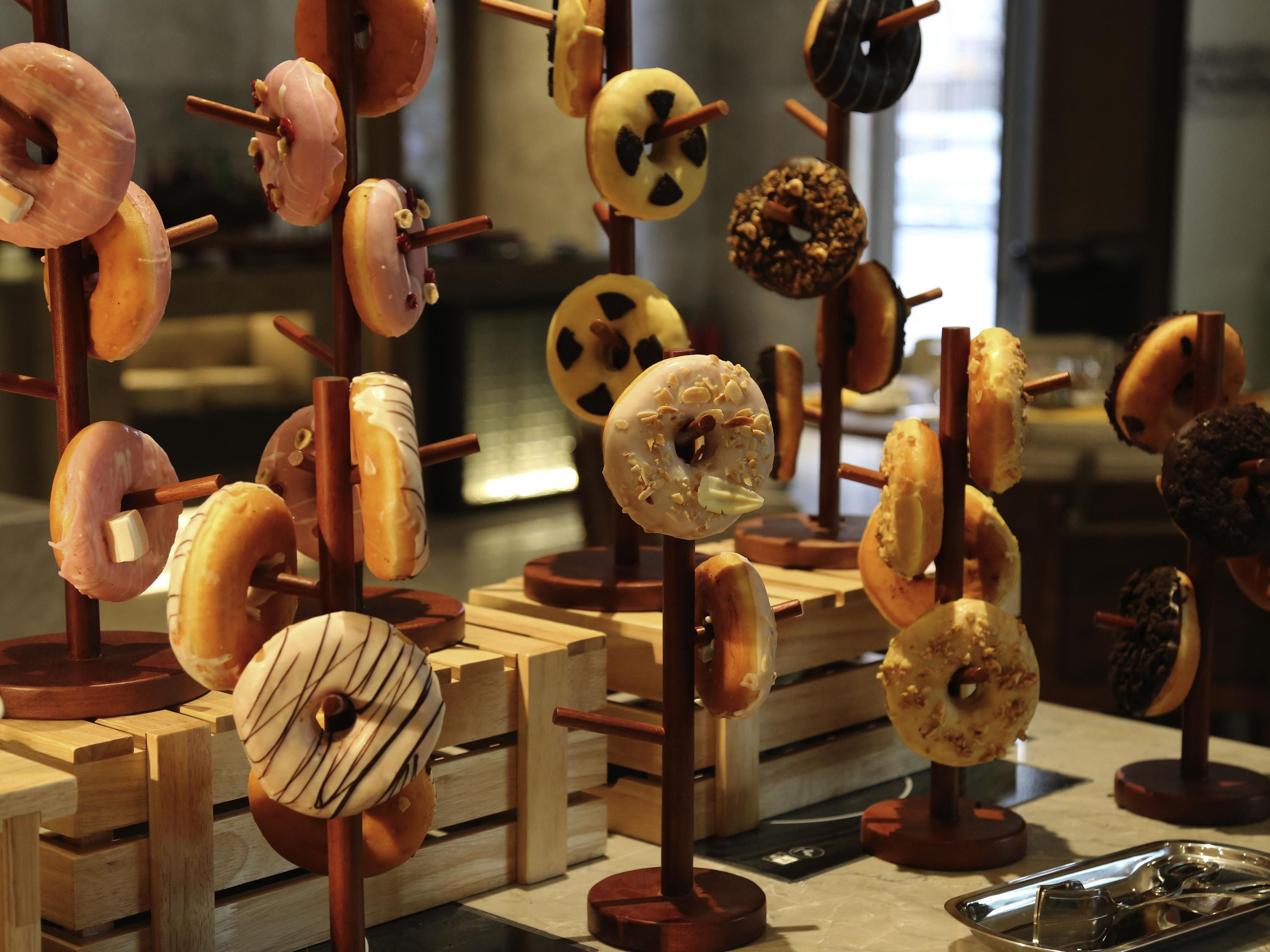 A display of various donuts on wooden stands.