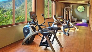 A gym with cardio equipment, a yoga mat, and a view of mountains. - Coulibri Ridge (Soufriere)