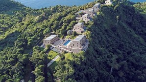 A coastal resort with multiple buildings, a swimming pool, and lush greenery. - Coulibri Ridge (Soufriere)
