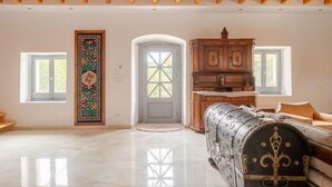 A spacious room with a high wooden ceiling, a large wooden cabinet, a patterned rug, and a vintage trunk. - Serenity Villa Retreat in Pidasos (Pylos-Nestoras)