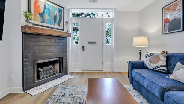A living room with a fireplace, a blue sofa, and a door leading outside.