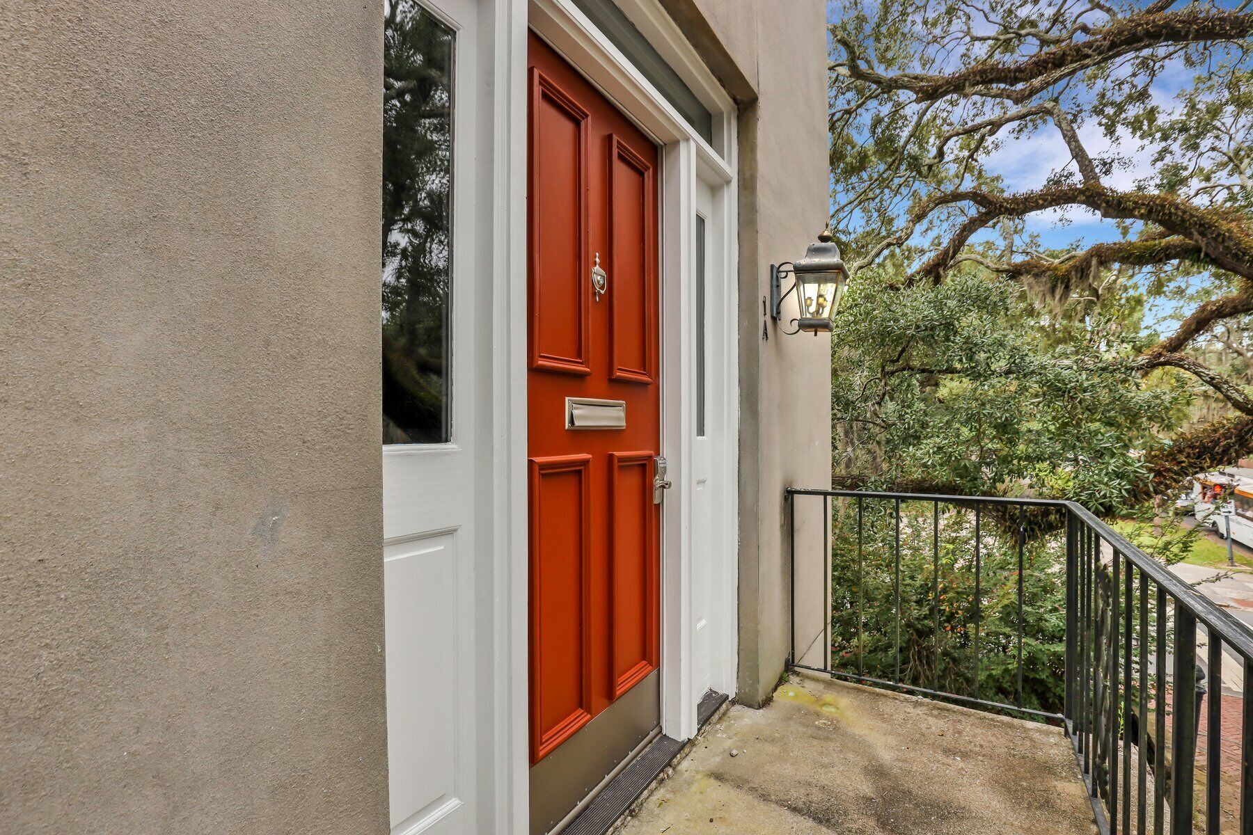 Une porte rouge avec une fente pour le courrier, une porte blanche et une petite fenêtre.