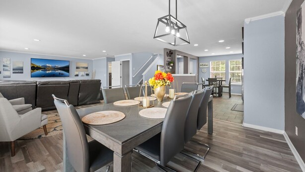 A modern dining area with a large table, chairs, and a central vase with flowers. - Ideal for Families & Groups | Theatre | Pet Friendly | Firepit | Spacious (Brighton)