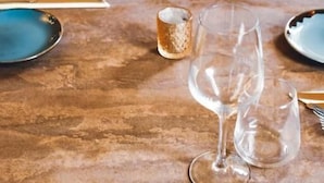 A dining area with round tables set for two, each with a wine glass, a water glass, and cutlery. - The Old Crown Coaching Inn (Faringdon)