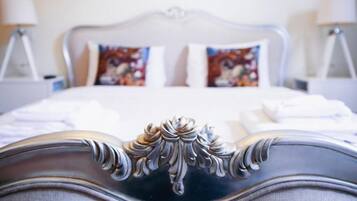 A bed with a decorative headboard, two pillows with floral patterns, and two bedside lamps.