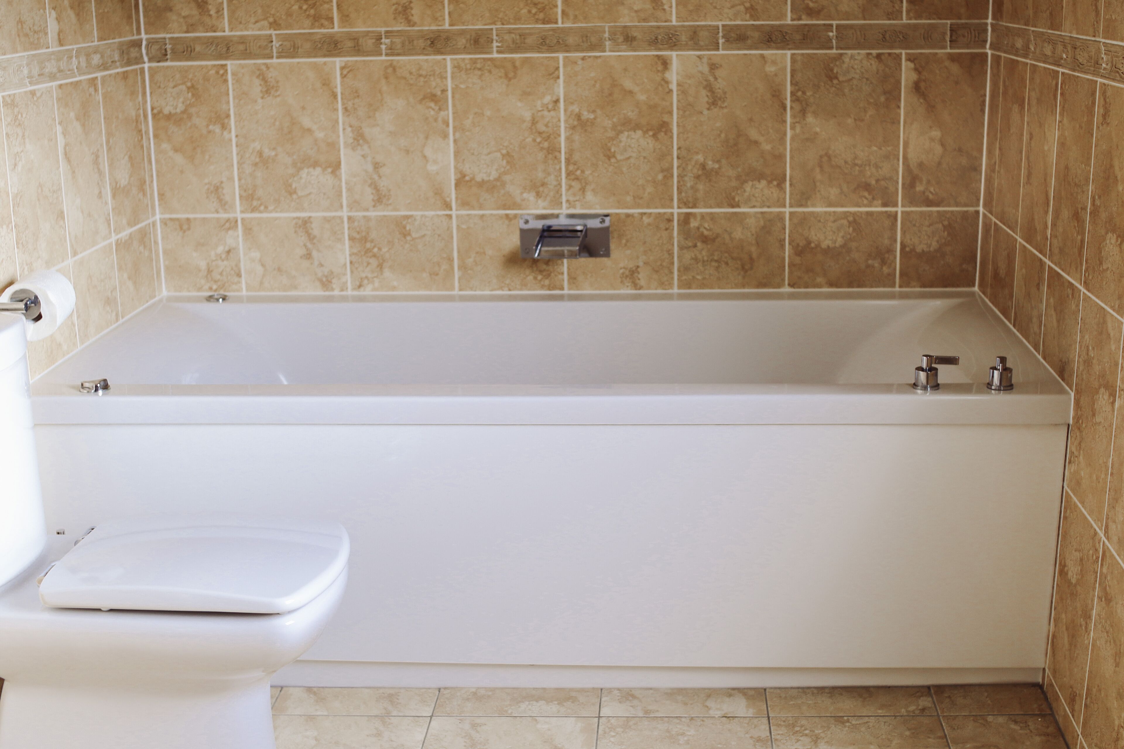 Un baño con bañera, inodoro y toallero.