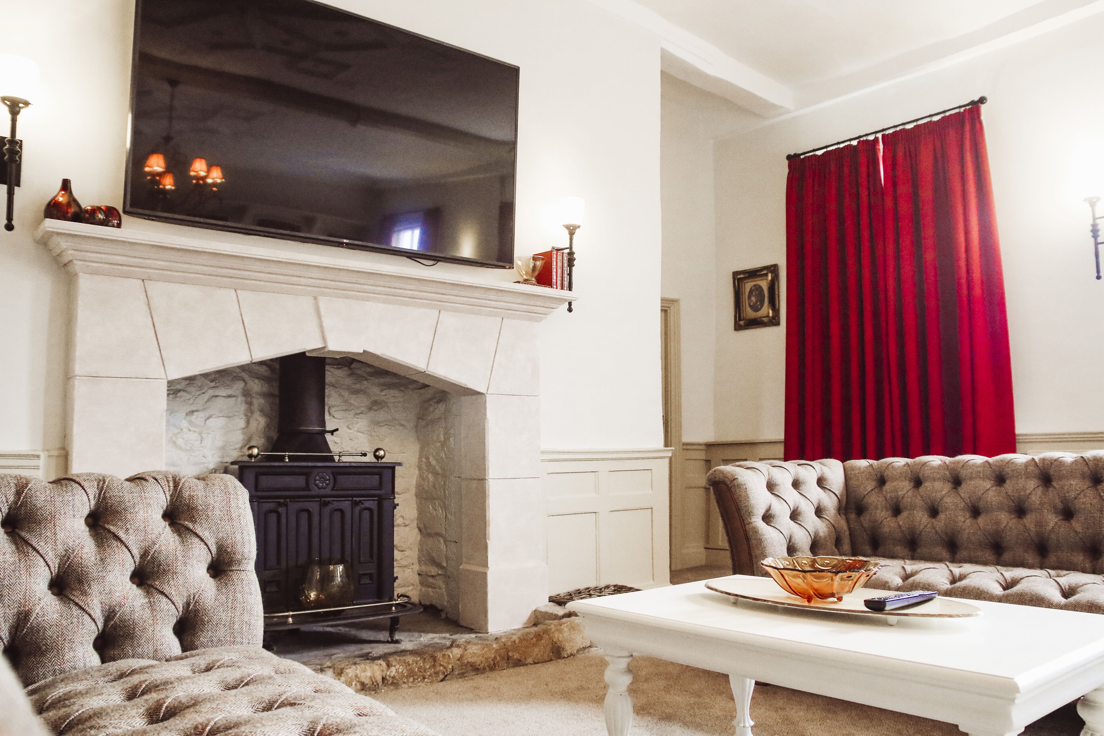 A living room with a fireplace, a television, a sofa, and a table.