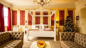 A luxurious bedroom with a four-poster bed, a chandelier, and a Christmas tree. - The Old Crown Coaching Inn (Faringdon)