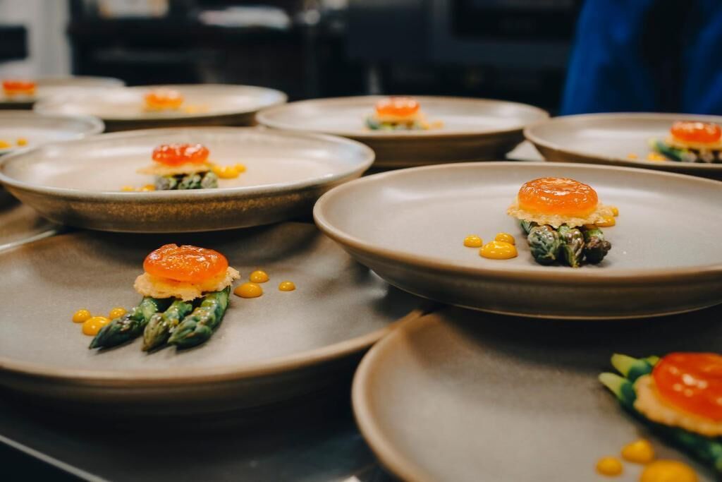 A series of dishes with a central garnish, possibly a type of caviar, on a plate.