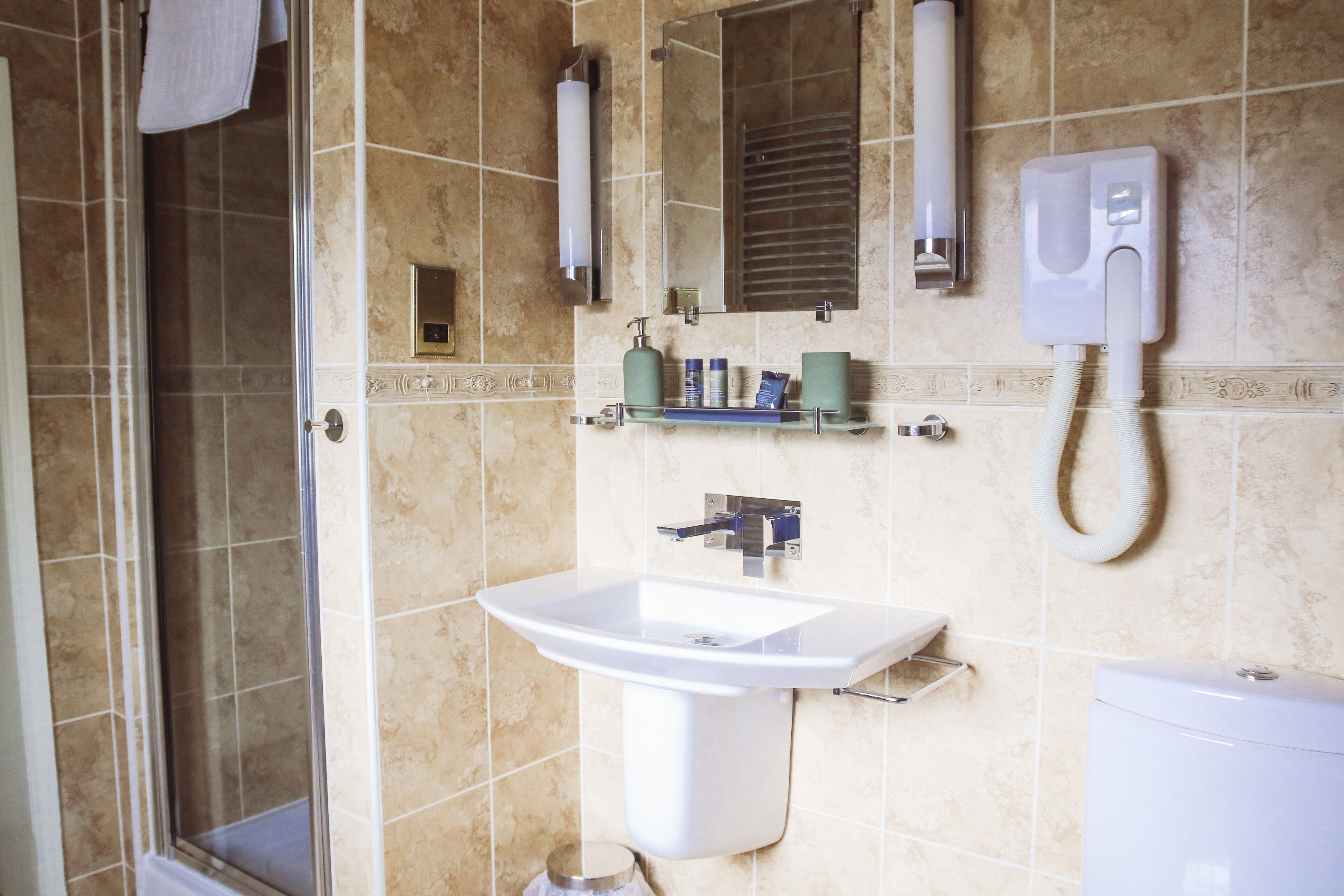 Een badkamer met een douche, wastafel en toilet.