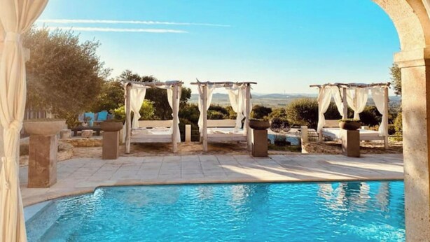 Zona de piscina con vistas despejadas del paisaje, incluyendo árboles y una lejana línea de horizonte.