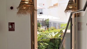A hotel entrance with a sign reading "SALIDA" (exit), a fire alarm pull station, and a staircase leading outside.