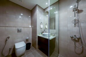 Un baño moderno con inodoro, lavamanos y ducha.