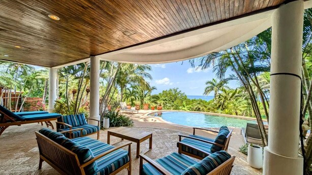Un espace extérieur abrité, doté de chaises longues et d’une piscine.