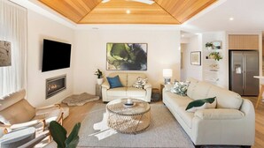 A modern living room with a fireplace, a round coffee table, and a sofa. - Luxurious Privacy in Exquisite Home, Walk to Golf (Cowes)