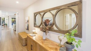 A hallway with a wooden console table, a large mirror, and a potted plant. - Luxurious Privacy in Exquisite Home, Walk to Golf (Cowes)