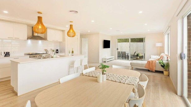 A modern kitchen with white cabinetry, a central island, and pendant lighting.